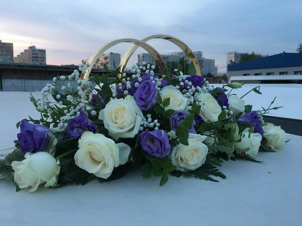 Композиция из цветов и колец на крыше свадебного авто